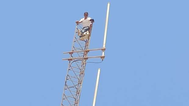 شخص يتسلق عمود شبكة للإتصالات و يُهـدِّد برمي نفسه ببوجدور.